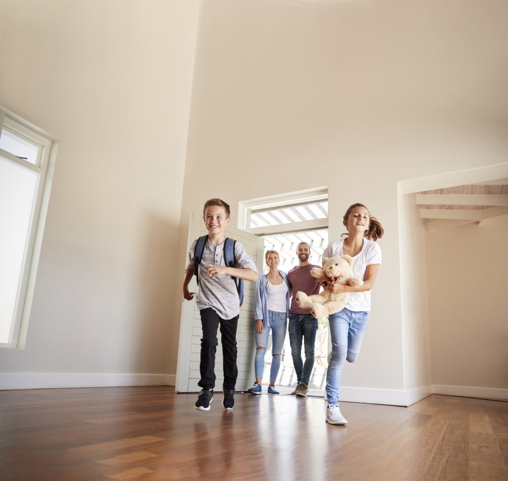 Family Opening Door And Walking In Empty Lounge Of New Home-Heating Installation